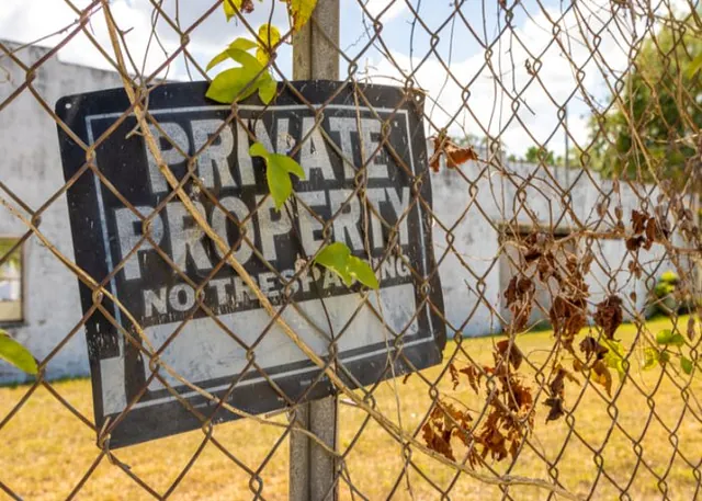 Private property sign on a fence with a reference to Trespassing Bail Bonds in Daytona Beach, FL