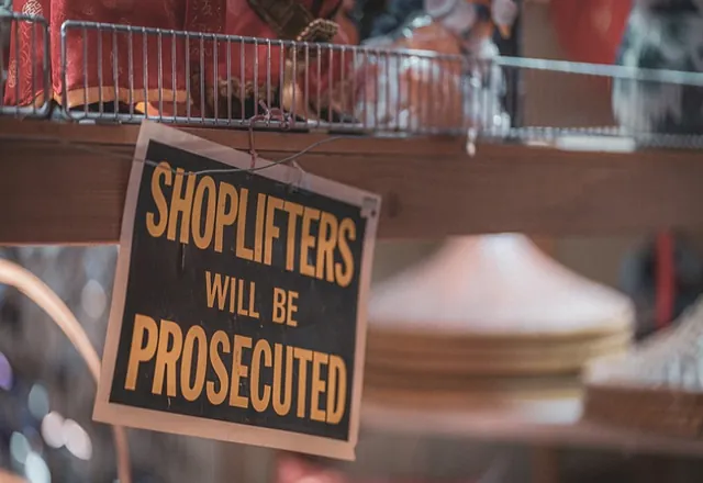 A sign stating Shoplifters will be prosecuted related to Shoplifting in Daytona Beach, FL